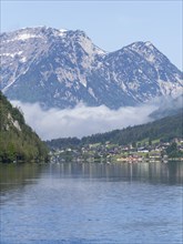 Morning mist drifts over a forest, Grundlsee in the morning light, near Gössl, Salzkammergut,