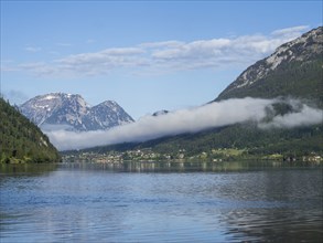 Morning mist drifts over a forest, Grundlsee in the morning light, near Gössl, Salzkammergut,