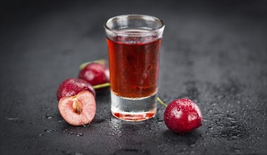 Some Cherry Liqueur on a slate slab as detailed close-up shot, selective focus