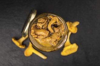 Portion of Preserved chanterelles on a rustic slate slab, selective focus, close-up shot