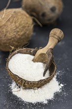 Healthy Coconut flour on a vintage slate slab (close-up shot, selective focus)