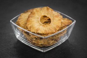 Portion of Dried Pineapple Rings on a rustic slate slab, selective focus, close-up shot