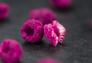 Dried Raspberries on a vintage slate slab as detailed close-up shot, selective focus