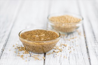 Mustard (sweet) on rustic wooden background (close-up shot)