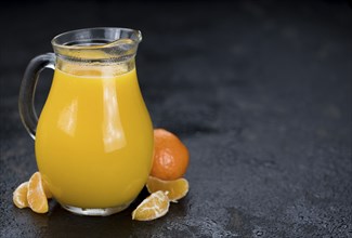 Portion of fresh made Tangerine Juice (close-up shot, selective focus)