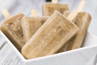 Some homemade Cola Popsicles (close-up shot, selective focus) on vintage background