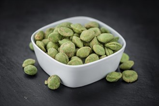 Some fresh Wasabi Peanuts on a vintage slate slab (selective focus, close-up shot)