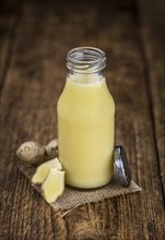 Healthy Ginger Sap on a wooden table as detailed close-up shot (selective focus)