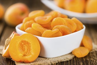 Dried Food (Apricots) on an old wooden table as detailed close-up shot (selective focus)