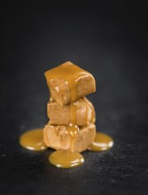 Caramel Sauce on a vintage background as detailed close-up shot (selective focus)