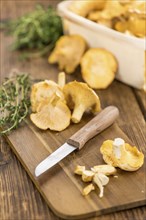 Chanterelles (freshly harvested) on an old wooden table as detailed close-up shot (selective focus)