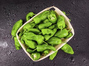 Portion of Raw Pimientos on a rustic slate slab, selective focus, close-up shot