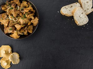 Some Fried Chanterelles on a slate slab as detailed close-up shot, selective focus