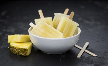 Homemade Pineapple Popsicles on a slate slab (selective focus, close-up shot)