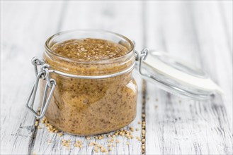 Mustard (sweet) on rustic wooden background (close-up shot)