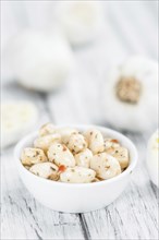 Garlic (preserved) as high detailed close-up shot on a vintage wooden table (selective focus)