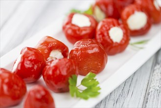 Fresh made Red Pepper (stuffed with cheese) on an old and rustic wooden table (selective focus,