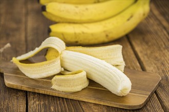 Whole Bananas on an old wooden table as detailed close-up shot, selective focus