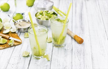 Fresh made Caipirinha with ingredients in the background