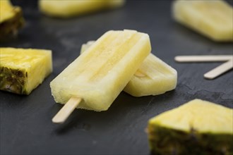 Homemade Pineapple Popsicles on a slate slab (selective focus, close-up shot)