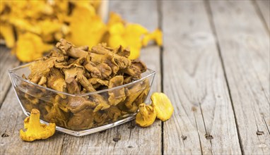 Preserved chanterelles on an old wooden table as detailed close-up shot, selective focus