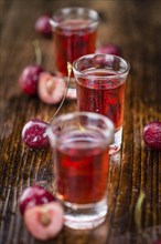 Homemade Cherry Liqueur on vintage background selective focus, close-up shot