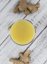 Healthy Ginger Sap on a wooden table as detailed close-up shot (selective focus)