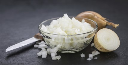 Portion of Chopped white onions as detailed close up shot on a slate slab, selective focus