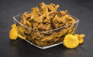 Portion of Preserved chanterelles on a rustic slate slab, selective focus, close-up shot