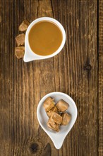 Caramel Sauce on a vintage background as detailed close-up shot (selective focus)