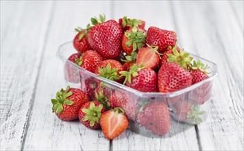 Strawberries as high detailed close-up shot on a vintage wooden table, selective focus