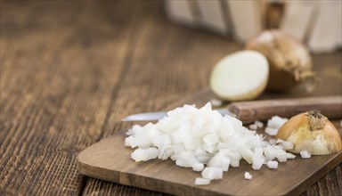 Chopped white onions on an old wooden table as detailed close-up shot, selective focus