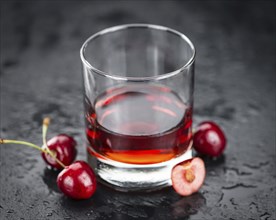 Some Cherry Liqueur on a slate slab as detailed close-up shot, selective focus