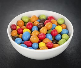 Portion of Cocolate coated Peanuts as detailed close up shot on a slate slab (selective focus)