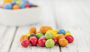 Cocolate coated Peanuts on an old wooden table as detailed close-up shot (selective focus)