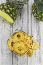 Pineapple rings (dried) on an old wooden table as detailed close-up shot, selective focus