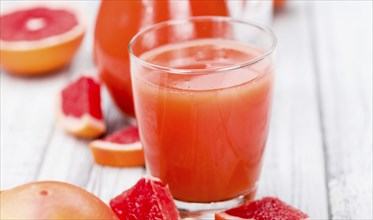 Portion of freshly squeezed Grapefruit Juice on a vintage background (selective focus, close-up