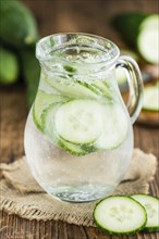 Cucumber Water on rustic wooden background as close-up shot