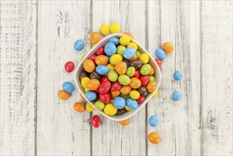 Fresh made Cocolate coated Peanuts on a vintage background (close-up shot)