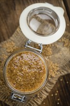 Homemade Sweet Mustard on an wooden table (selective focus) as detailed close-up shot