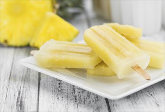 Fresh made Popsicles (Pineapple flavoured, selective focus) on a rustic background