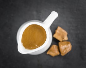 Caramel Sauce on a vintage slate slab (close-up shot, selective focus)