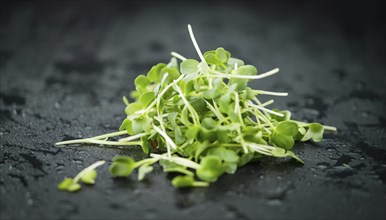 Portion of Cress as detailed close up shot on a slate slab (selective focus)