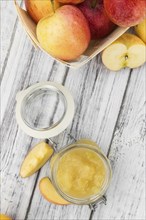 Portion of fresh made Applesauce (selective focus) on a wooden table