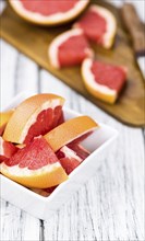 Chopped Grapefruits (selective focus) on a vintage background as detailed close-up shot