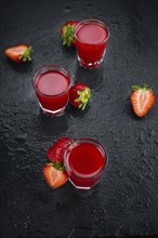 Some fresh Strawberry liqueur on a vintage slate slab, selective focus, close-up shot