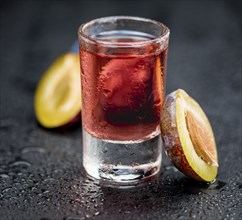 Fresh made Plum Liqueur on a vintage background as detailed close-up shot