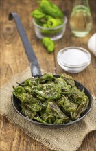 Pimientos de Padron on an old wooden table as detailed close-up shot, selective focus