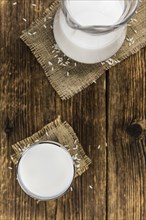 Wooden table with Rice Milk (detailed close-up shot, selective focus)