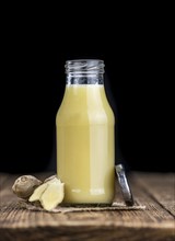 Healthy Ginger Sap on a wooden table as detailed close-up shot (selective focus)